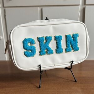 White Cosmetic Bag with Blue 'SKIN' Patch
